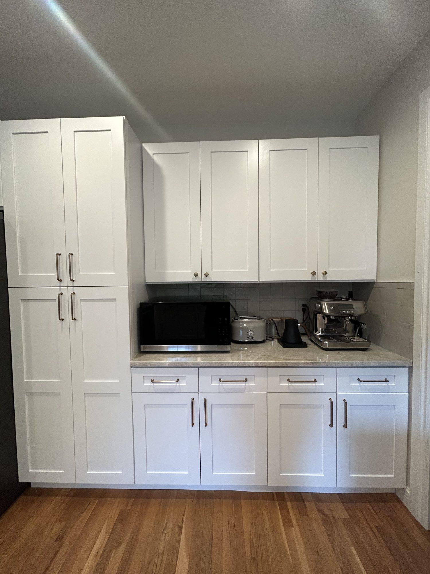 Floor-to-ceiling pantry wall with white shaker cabinets