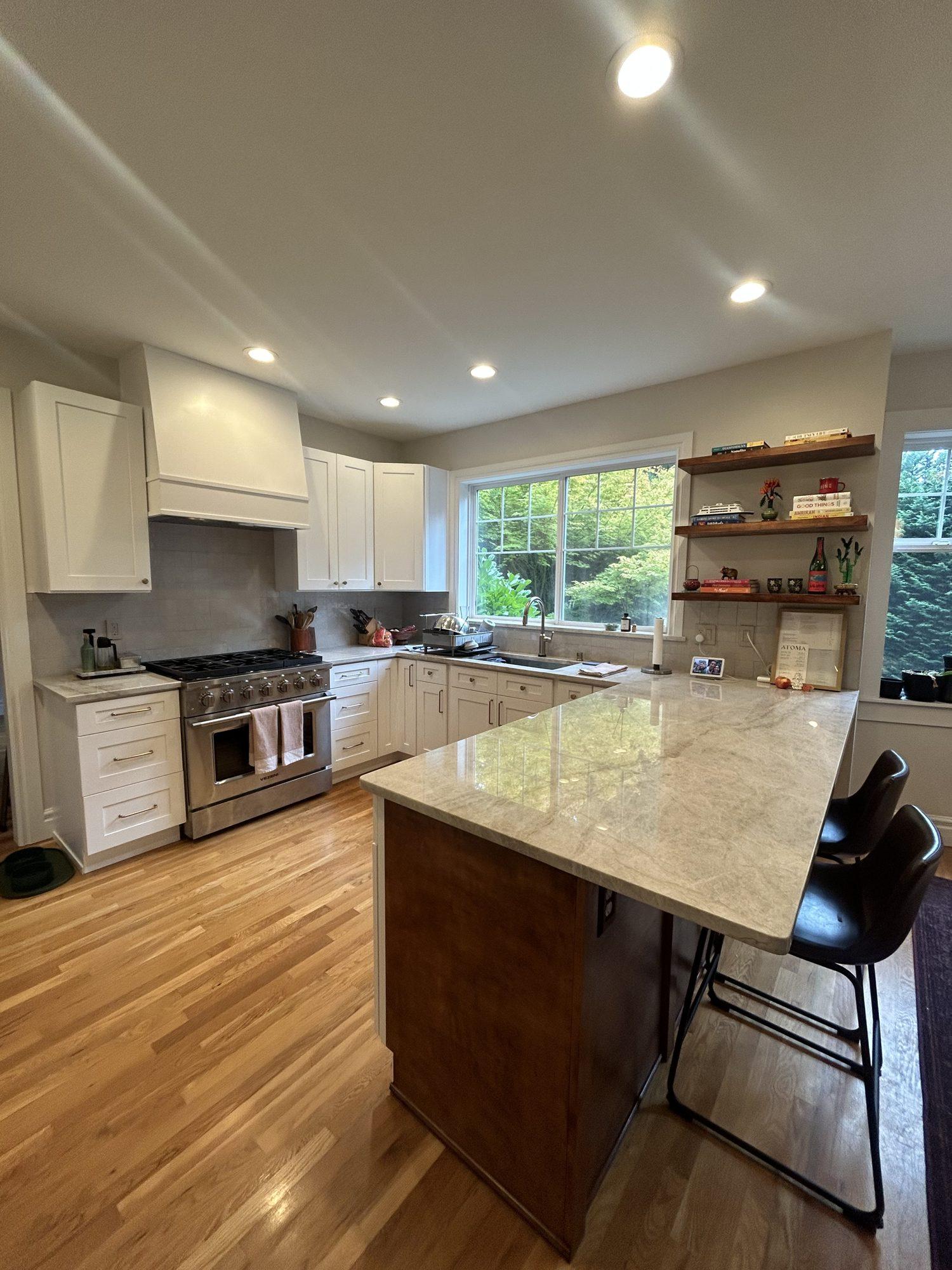 Completed kitchen remodel with white shaker cabinets and quartzite peninsula by Avalos Construction